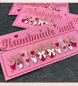 Detailed handmade press-on nails with 3D bows and heart gems on product sizing cards