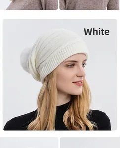 Détail du bonnet en maille blanche avec pompon duveteux et bordure côtelée élastique