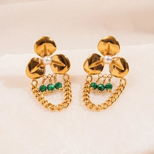Detail of gold floral earrings featuring white pearls and green malachite fringe accents