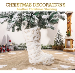 Detail of white faux fur Christmas stocking with golden feathers hanging on a pine tree