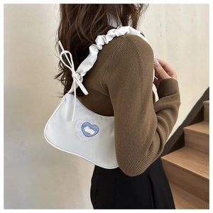 Detail of white shoulder bag with ruffled strap and heart-shaped bunny embroidery