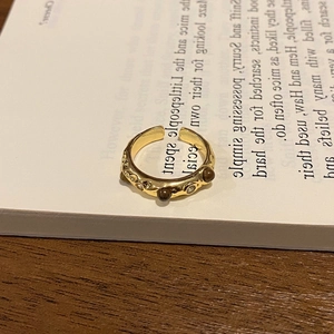 Detailed macro view of an 18k gold plated tiger eye ring on an open book page