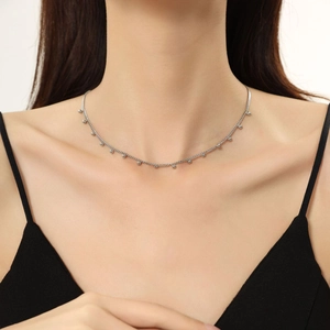 Dettaglio della collana girocollo minimalista con perline d'argento sul collo