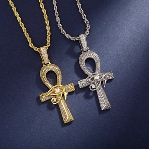Detailed close-up of gold and silver Ankh necklaces with iced-out Eye of Horus symbols