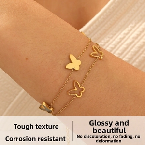 Close-up of dual-layer gold-plated stainless steel bracelet with hollow butterfly charms