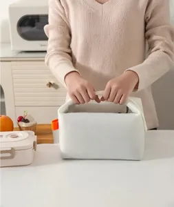 Detail showing the large opening and orange handle of the white insulated lunch bag