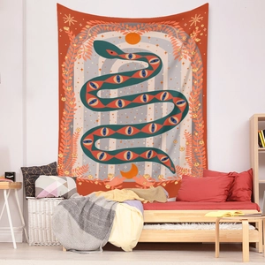 Detail of bohemian tapestry featuring mystic snake and celestial motifs in a bedroom setting
