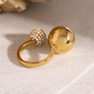 Detail of an 18k gold plated asymmetrical open ring with rhinestone and metal bead accent
