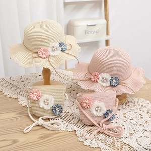 Dettaglio del set cappello di paglia con fiori fatti a mano e perle per bambina