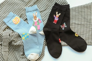 Detail of cotton crew socks featuring cute rabbit and planet jacquard patterns in blue and black