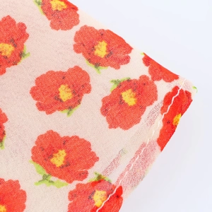 Macro-opname van de rode bloemenprint textuur en fijne stiksels op de stof van de jurk