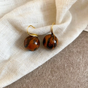 Gros plan de boucles d'oreilles en acrylique léopard avec crochets dorés polis