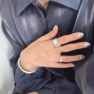 Detail of S925 sterling silver wave ring and bow ring worn on model hands