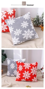 Détail des housses de coussin de Noël en peluche avec flocons de neige rouges et gris
