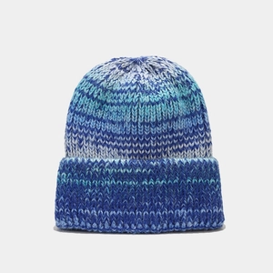 Détail du bonnet en tricot dégradé bleu et blanc avec texture épaisse et revers