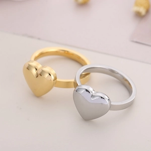 Detailed macro view of 18K gold and silver heart-shaped polished stainless steel rings