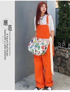 Close-up of a large beige canvas tote bag with vintage cartoon illustrations in a street style