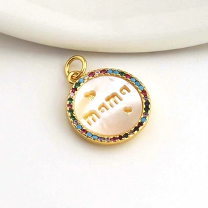 Macro detail of gold-plated Mama pendant with colorful zircons and white mother of pearl