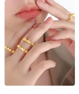 Close-up of stacked gold heart-shaped rings on model fingers featuring a stylish jagged edge design