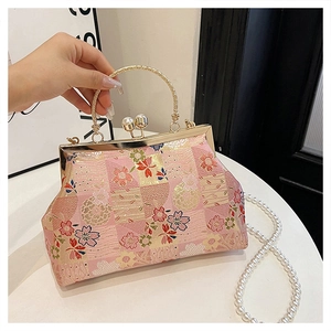 Detail of pink floral embroidery on banquet bag with pearl clasp and golden handle