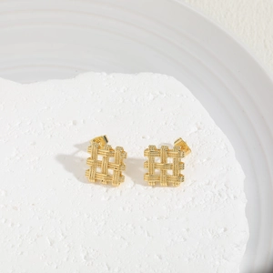 Detail of gold geometric square stud earrings with woven texture on white stone