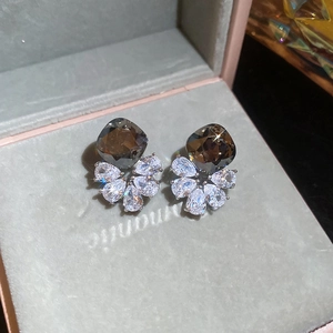 Detailed view of silver stud earrings with smoky grey cushion stone and teardrop zircons