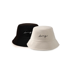 Detailed embroidery of 'lazy' cursive text on black and cream cotton bucket hats
