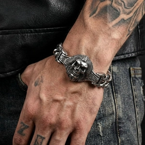 Close-up of a vintage skull and wolf head steel bracelet on a biker leather jacket