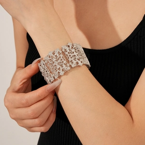 Close-up of vintage silver lace-patterned cuff bracelet with rhinestones on model