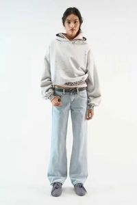 Detail of grey oversized hoodie with leopard print layer and light blue jeans outfit
