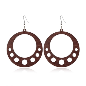 Detailed view of hollow dark brown wood round earring with gradient circular cutouts