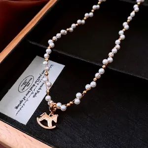 Elegant gold plated pearl necklace featuring a detailed rocking horse pendant on black velvet