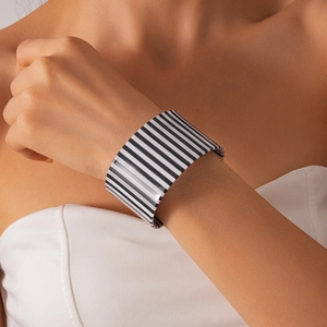 Macro shot of wide open cuff bracelet featuring classic black and white striped resin pattern
