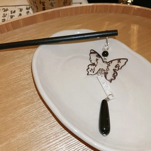 Detail of a Chinese style hair pin with butterfly pendant and black teardrop bead