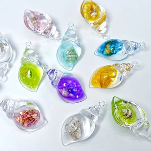 Macro shot of colorful luminous conch pendants with glitter and internal shell detail