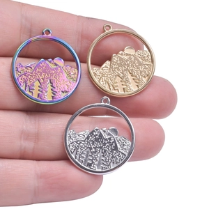 Three-color circular mountain pendant in rainbow, gold and silver finish on hand