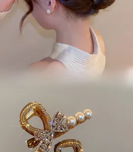Detail of gold bow hair claw clip with pavé rhinestones and dangling pearls