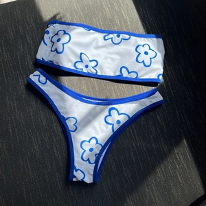 White bandeau bikini set with blue floral outlines and contrasting blue trim details