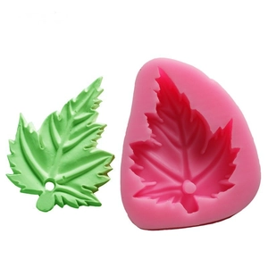 Pink silicone maple leaf mold shown with a green leaf fondant on a white background