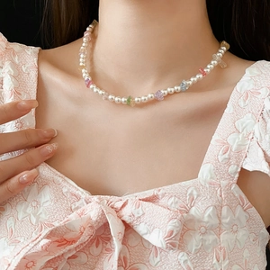Close-up of pearl and colorful gravel beaded necklace on model for a sweet summer look