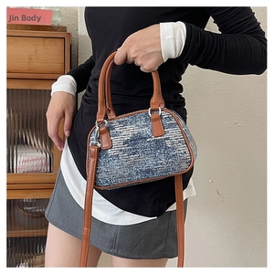 Detailed shot of wavy blue and silver sequins on the Boston bag with brown leather handles