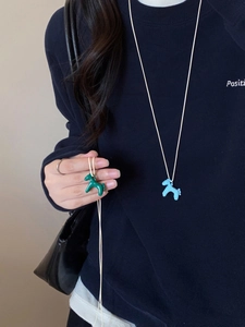 Detail view of colorful leather pony charm necklace showing stitched craftsmanship