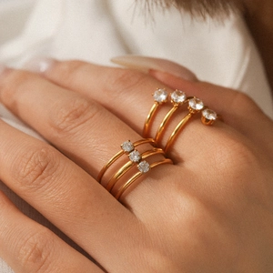 Detailansicht von geschichteten Goldringen mit Zirkonia-Besatz im minimalistischen Stil