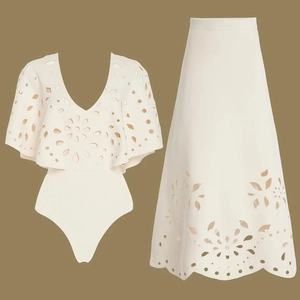 Detail of white two-piece swimsuit set with laser-cut floral embroidery on top and skirt
