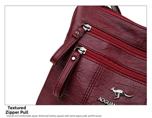Detail of burgundy PU leather crossbody bag with multiple silver metal zippers