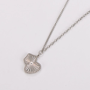 Macro shot of silver calabash pendant with sunburst texture on a delicate link chain