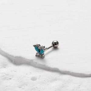 Detail view of butterfly stud earring featuring blue stones and clear crystals