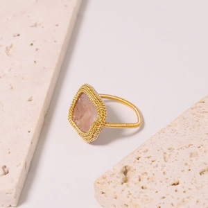 Baroque pink pearl ring with gold wire wrapped band on natural stone background