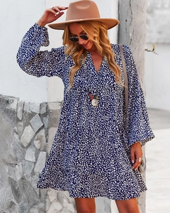 Detailed close-up of dark blue long-sleeve V-neck dress with white polka dots