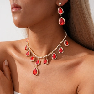 Détail de la parure avec pendentifs goutte rouge, placage doré et cristaux brillants